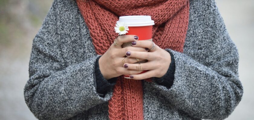 person holding red and white disposable cup