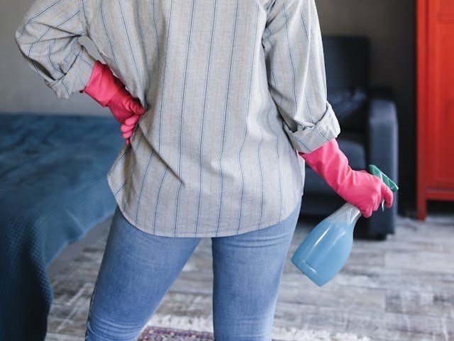 a-person-wearing-rubber-gloves-holding-a-spray-bottle