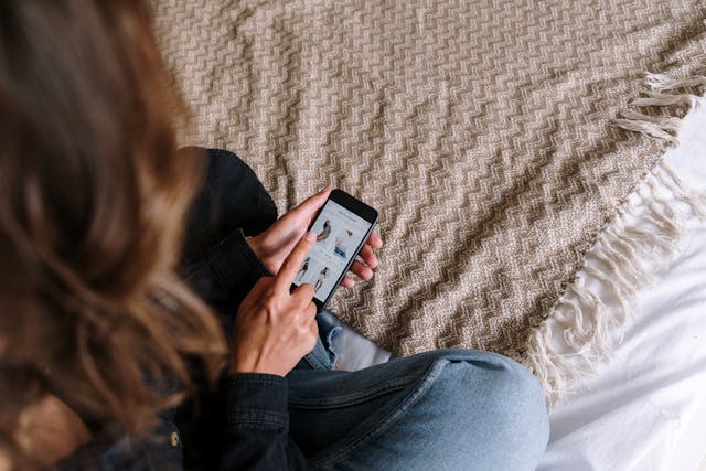 woman-in-blue-denim-jeans-holding-silver-iphone