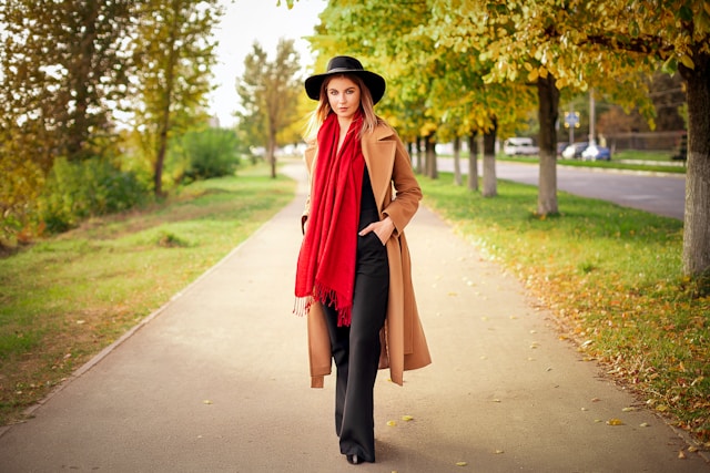 a-woman-in-a-hat-and-coat-is-walking-down-a-path